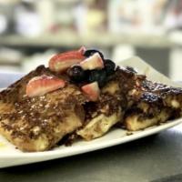 French Toasted Bread Pudding · Topped with seasonal berries and caramel sauce.