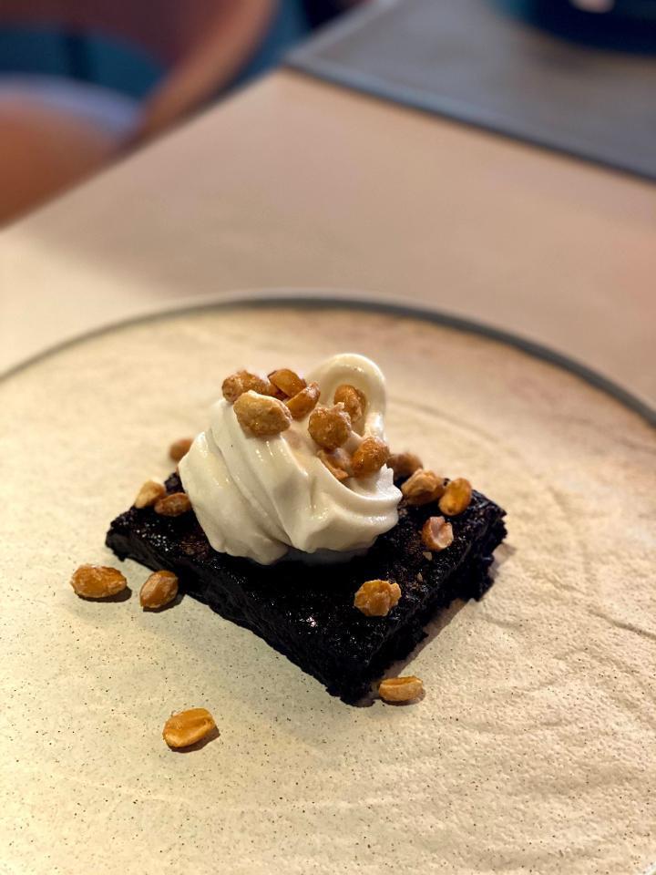 CHOCOLATE BROWNIE · Dark chocolate brownie with hot fudge, vanilla soft serve and candied peanuts (Contains Gluten and Nuts)