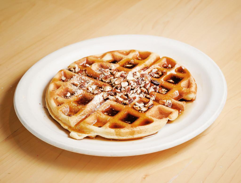 Georgia Pecan Waffle · Golden brown waffle filled and topped with Georgia pecans and lightly dusted with powdered sugar then served with whipped butter and warm syrup.