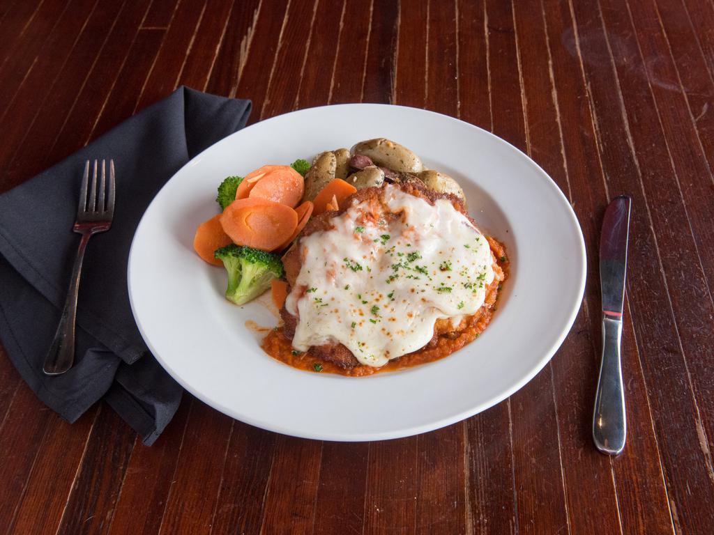 CHICKEN PARMESAN · Corn flake crusted chicken breast, mozzarella, marinara, and seasonal vegetables. Choice of garlic mashed potatoes or herb-roasted fingerlings.