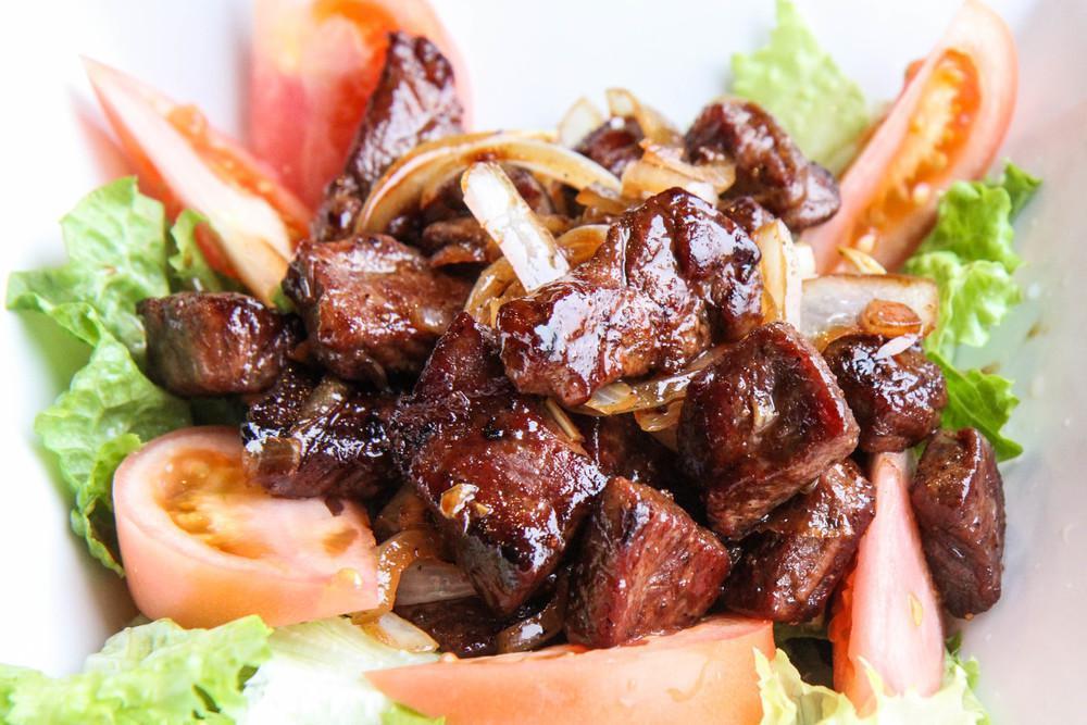 Shakin’ Steak (BO LUC Lac) · Bo luc lac. Tender marinated steak cubes tossed with onions and served over a bed of lettuce and tomatoes with a side of lemon dipping sauce.
