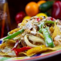 Nachos Fajitas · Your choice of chicken or beef slices over a bed of golden corn chips, topped with grilled o...