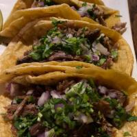 Tacos de Barbacoa · 3 slow cook lamb meat, cilantro and onions. Served with rice and beans.