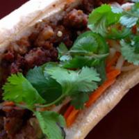 Minced Pork Banh Mi Sandwich · With onions and salty sweet seasonings. Dressed with a tangy carrot and daikon relish, cucum...