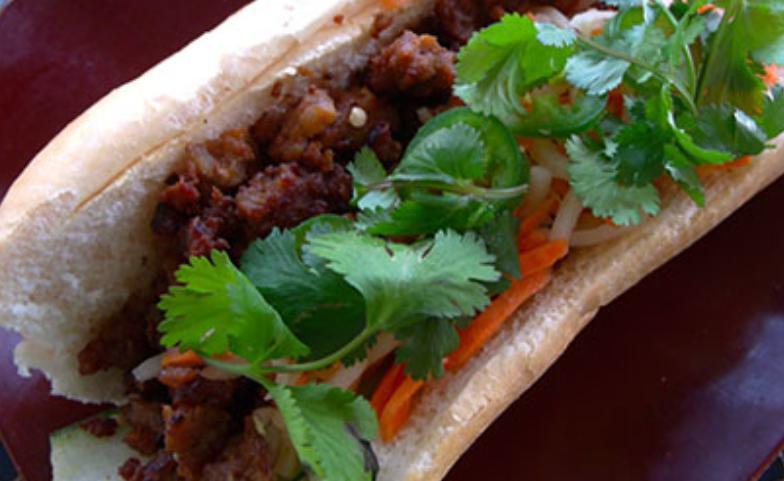 Minced Pork Banh Mi Sandwich · With onions and salty sweet seasonings. Dressed with a tangy carrot and daikon relish, cucumbers, jalapenos, cilantro and mayo on a toasted baguette.
