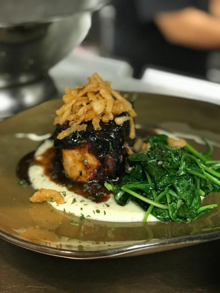 Grilled Pork Chop · Served with roasted cauliflower puree, Garlic spinach, port wine reduction, and crispy onions