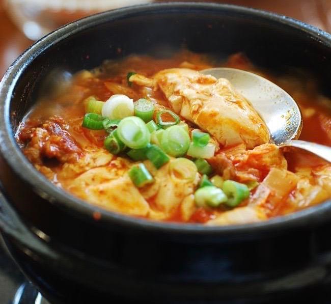 Sun Du Bu JjiGae · Spicy soft tofu stew with zucchini, onions and mushrooms. Spicy.