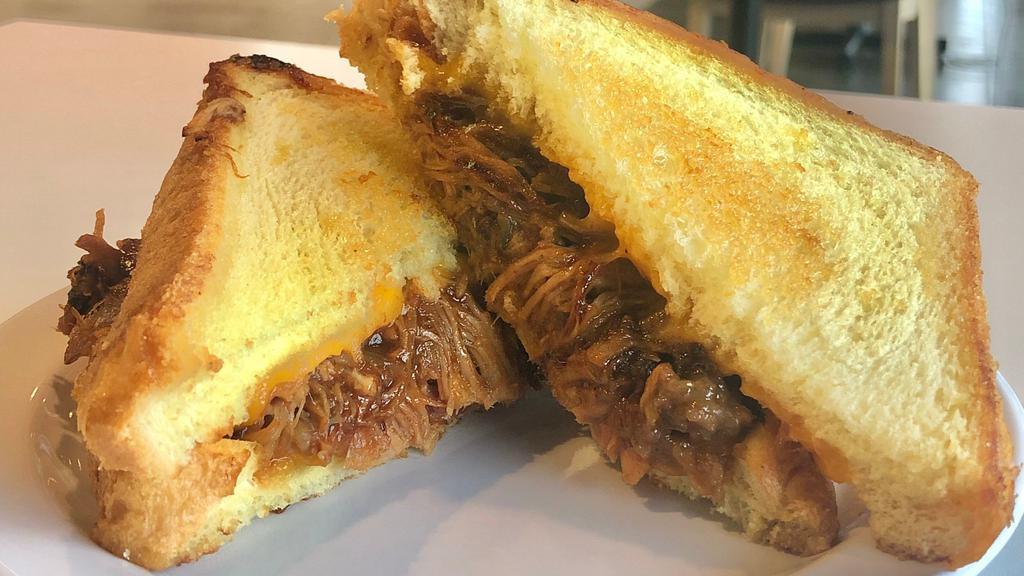 Pulled Pork Grilled Cheese · This is grilled cheese taken to the next level. Tender Pulled Pork smothered in BBQ sauce and melted cheese.
