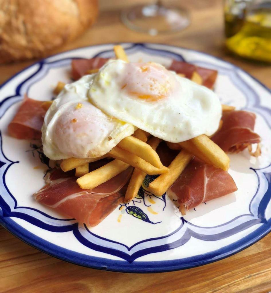 Huevos Rotos · Broken eggs french fried potatoes, Spanish ham and fried include 1 coffee with milk.