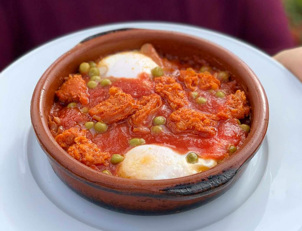 Huevos a la Flamenca · Eggs, ham and sausage in tomato sauce.