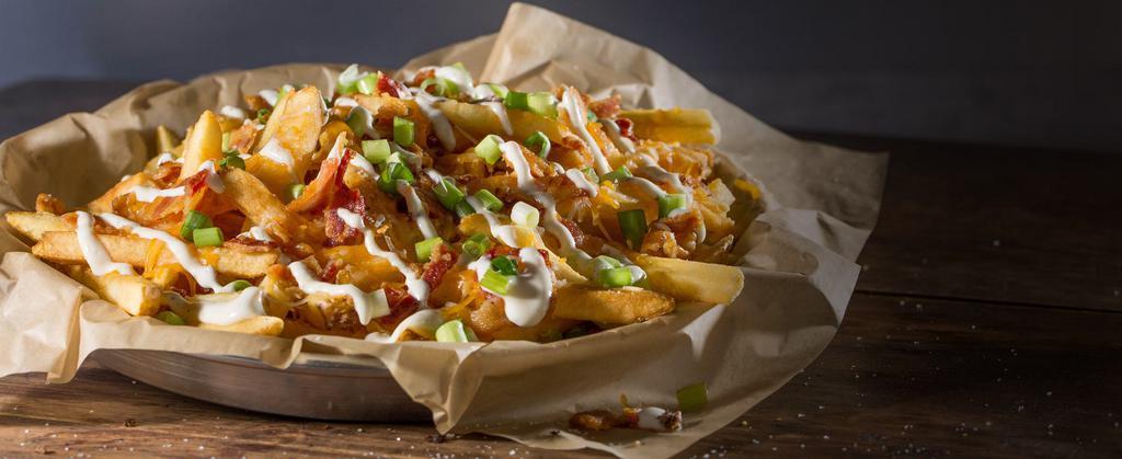 Bacon Cheese Fries · Because why not add bacon? Our fries topped with a generous portion of Cheddar Jack cheese, a layer of chopped bacon, fresh scallions, and drizzled with ranch sauce.