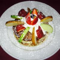 Gluten Free Pancakes · 3 Pancakes topped with whipped cream and powder sugar and maple syrup on the side
