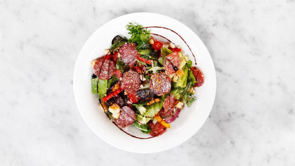 The Italian Salad · Mixed greens, romaine hearts, Neapolitan salami, bell peppers, grape tomatoes, cucumbers, red onions, Kalamata olives, Parmesan cheese and crushed croutons. Tossed in Italian dressing.
