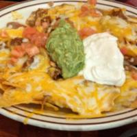 2. Super Nachos · Special nachos topped with beans and melted cheese, freshly chopped tomato, guacamole and so...