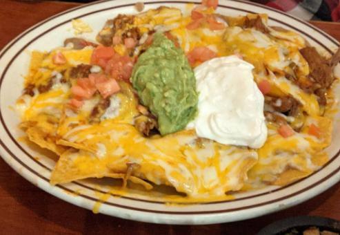 2. Super Nachos · Special nachos topped with beans and melted cheese, freshly chopped tomato, guacamole and sour cream.