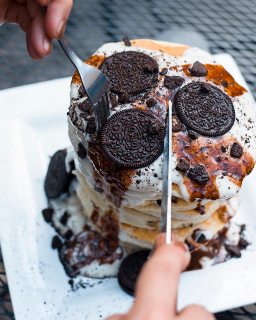 Oreo’s and Cream Pancakes · Crushed Oreos sprinkled in a short stack of pancakes and topped with sweet cream frosting and chocolate syrup.