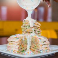 Birthday Cake Pancakes · Birthday quins sprinkled in a short stack of vanilla cake pancakes topped with sweet cream f...