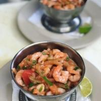 Ceviche de Camarones · Marinated shrimp with onions and tomatoes.