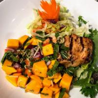 Mango Salmon Salad · 8 oz. salmon marinated in Thai herbs and spices, charcoal grilled and served on top of a Tha...