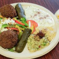Vegetarian Sampler · Falafel and grape leaves with Greek salad, baba ghannouj, hummus and tzatziki. Served with p...