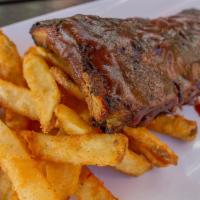 Baby Back Ribs · Slow cooked, fall of the bone tender baby back pork ribs, served with fries and veggies cove...
