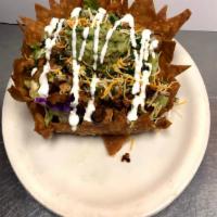 Baja shell  · A big fried tortilla in a shape of a tostada bowl with beans , salad , guacamole , cheese , ...