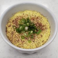 Turmeric Grits · Yellow grits seasoned with turmeric, cheese and our special spices, topped with scallions.