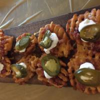 Waffle Bites · Crispy potato waffles smothered in cheese, bacon, sour cream  and topped with a jalapeno sli...