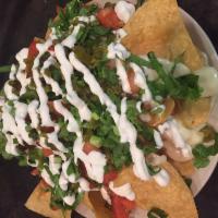 Kick Azz Nachos · Fried tortilla chips, homemade queso cheese, jalapenos, fresh cut lettuce, chopped tomatoes ...