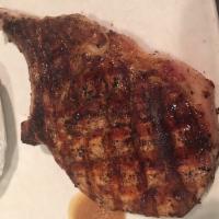 Flame Grilled Pork Chop · A 12 oz. thick cut bone in pork chop garnished with applesauce. Served with a salad and 1 si...
