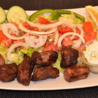 Lamb Tikka Over Salad · 2 skewers with salad and tzatziki sauce.