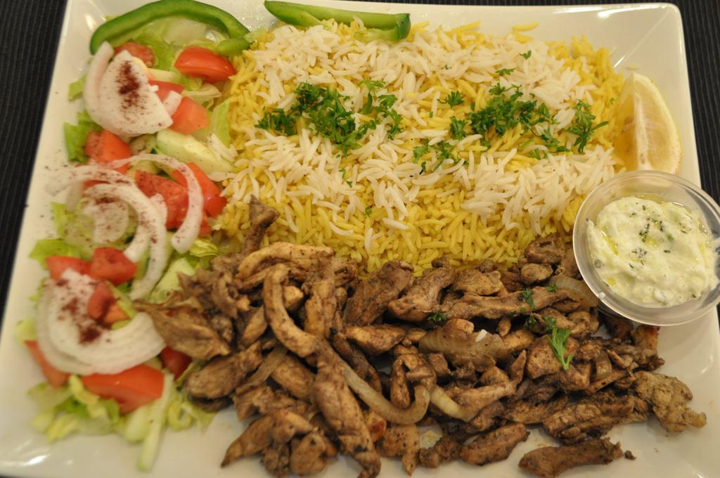 Chicken Shawarma Over Rice · Slices with rice, salad and tahini sauce.