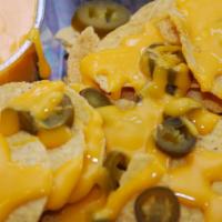 Nachos · Crisp tortilla chips smothered in melted cheddar cheese and topped with sliced jalapenos.
