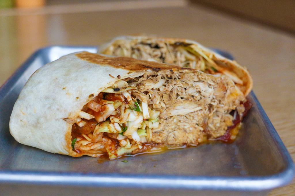 Hawaiian Chicken Burrito  ·  Pulled Chicken, rice, bacon, onion, pineapple chipotle sauce, chihuahua cheddar blend, slaw, all wrapped in a flour tortilla