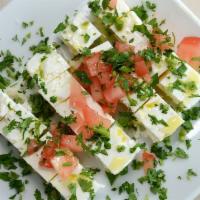 Feta and Tomatoes · Delicious imported feta cheese served with fresh tomatoes in garlic oil.