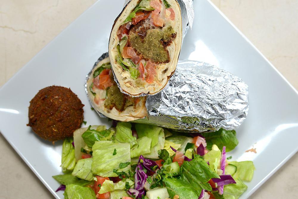 Falafel Sandwich · Golden fried falafel wrapped in choice of bread served with hummus, lettuce, tomatoes and onions served in a  tortia  bread with choice of side( rice,salad,french fries)