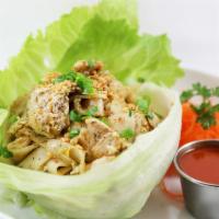 86. Roasted Chicken Noodle · Roasted flat noodle, slice chicken, garlic, green onion on the bed of lettuce wrap served wi...