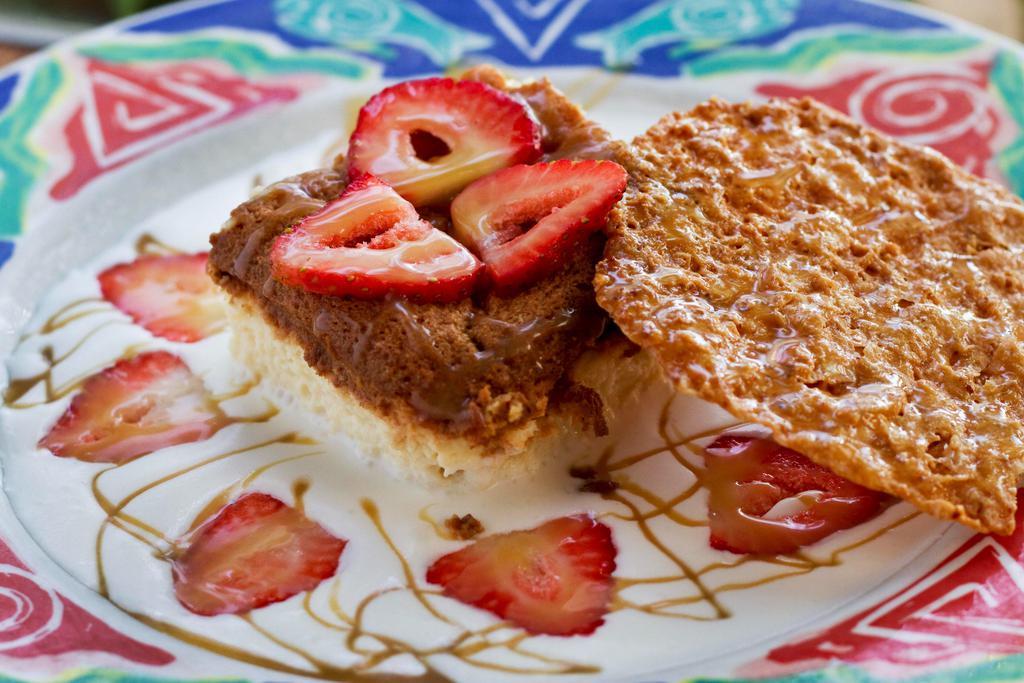 Tres Leches · Traditional mexican cake made with three sweet creams on a bed of creme fraiche, topped with strawberries and accompanied by a praline cookie.

* Praline cookie contains nuts*