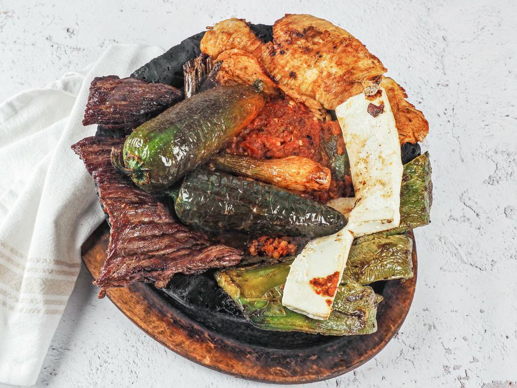 Molcajete · chicken breast, one steak, 6 shrimps, chorizo, grilled fresh cheese, nopales, 2 cambray onions, rice beans with red sauce, guacamole and pico de gallo.