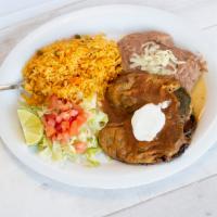 Chiles Rellenos Dinner · Two stuffed poblano peppers topped with our special red sauce. Served with a side of rice, b...