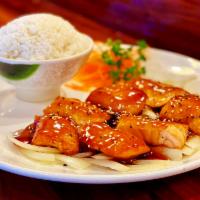 Salmon Teriyaki · Grilled salmon fillets on a bed of grilled onions, topped with teriyaki sauce and sesame see...