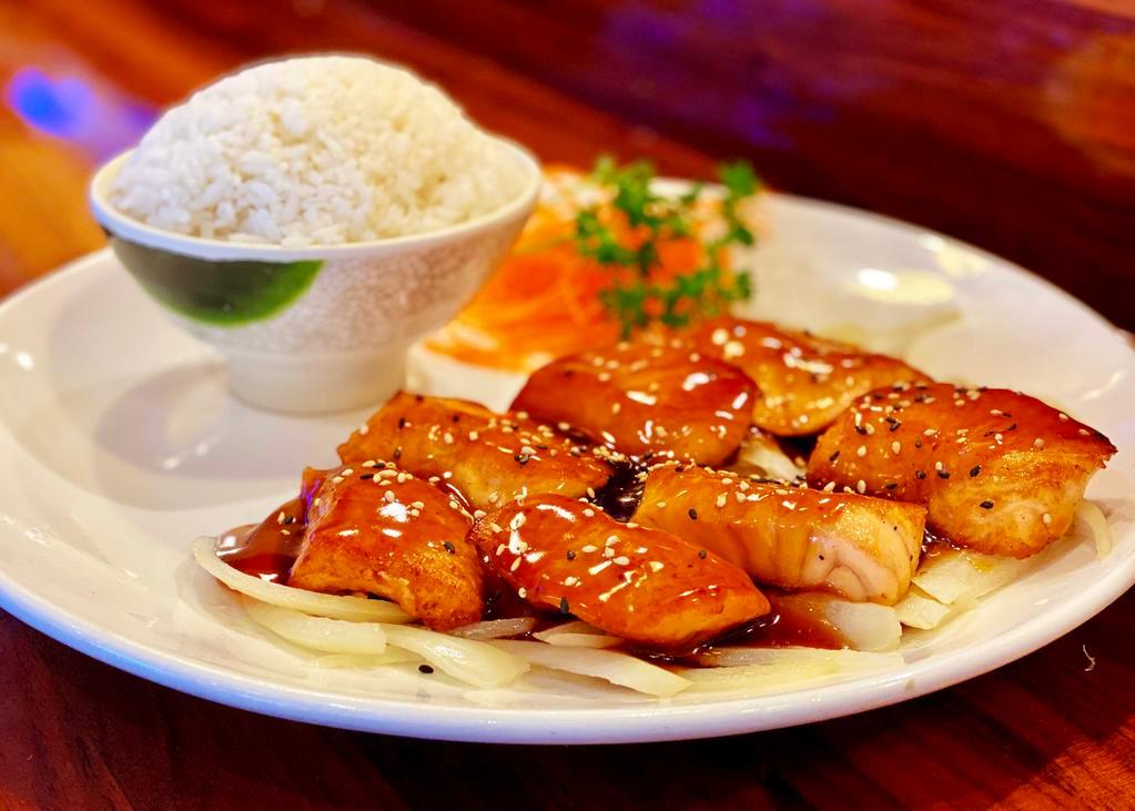 Salmon Teriyaki · Grilled salmon fillets on a bed of grilled onions, topped with teriyaki sauce and sesame seeds. Served with white rice & miso soup/house salad.
