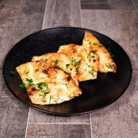 Garlic Naan · Tandoori naan mixed with a subtle touch of garlic, baked to perfection in a clay oven. Vegan.