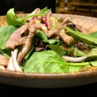 NAM TOK (BEEF SALAD) · Grilled beef, Scallion, Shallots, Cilantro, Toasted rice powder, Chili powder, Lime dressing.