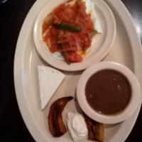 Huevos Rancheros Breakfast · Served with fried plantain, cream, cheese, and bacon.