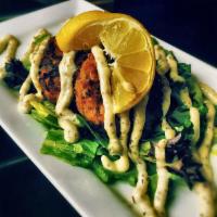 Fire Roasted Crab Cakes · 2 fire roasted crab cakes, served over greens and finished with a lemon oregano aioli.