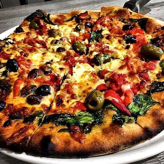 Mediterranean Vegetarian Pizza · Garlic herb oil, sun dried tomatoes, mixed olives, spinach, roasted red peppers, feta cheese and Napa cheese blend.