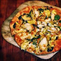 Spinach Artichoke Pizza · Garlic herb oil, fire roasted chicken, artichokes, spinach, Parmesan and Napa cheese blend.