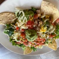 Ensalada  · Crisp mixed greens topped with seasoned beef or chicken, tomatoes, American and Monterey Jac...