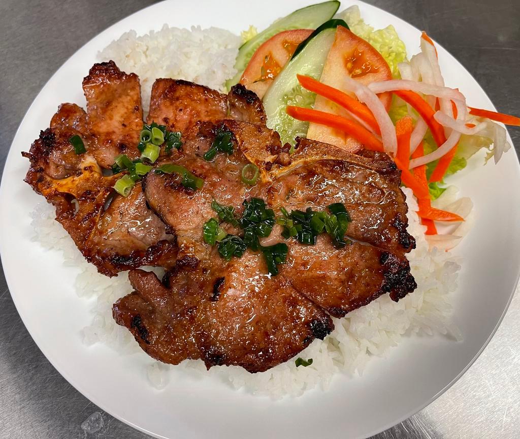 61. BBQ Pork Chops Rice Plate · Com Suon. Traditional vietnamese pork chop rice plate served with small salad, cucumber, tomato, pickled veggies.